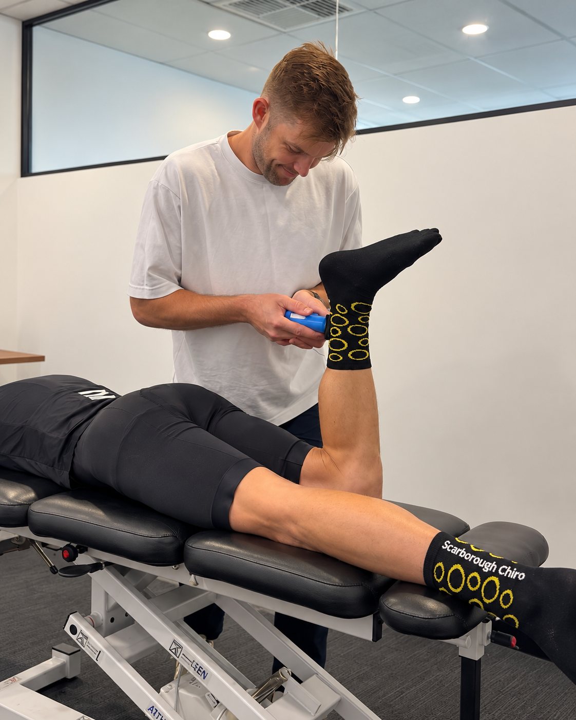 Tim measuring a patient's hamstring strength with a handheld dynamometer