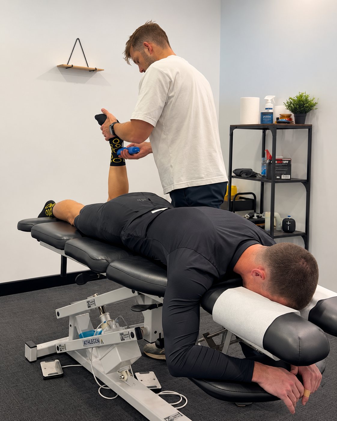 Tim testing a patient's leg strength with a handheld dynamometer