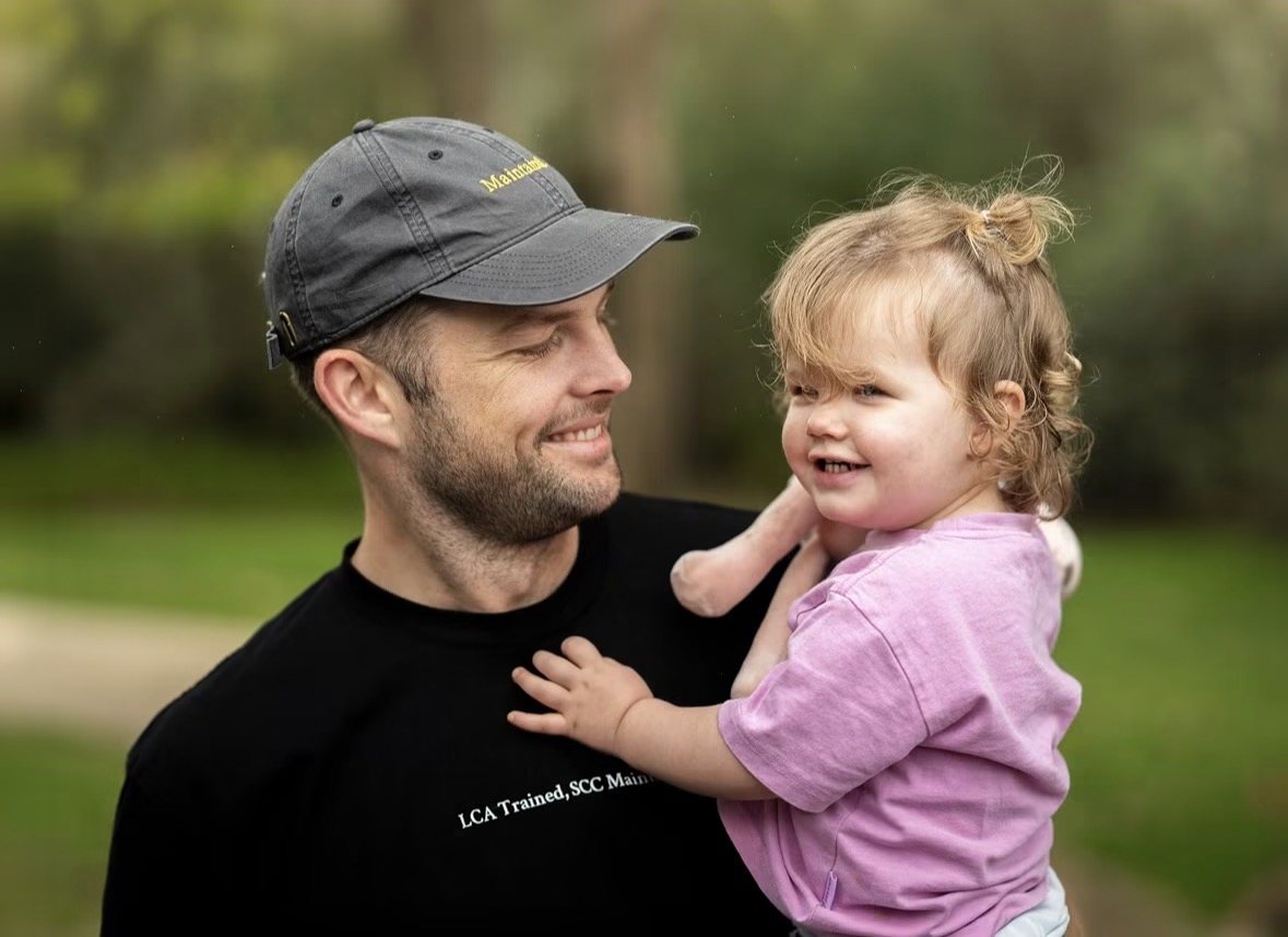 Tim holding his daughter Parker in the park