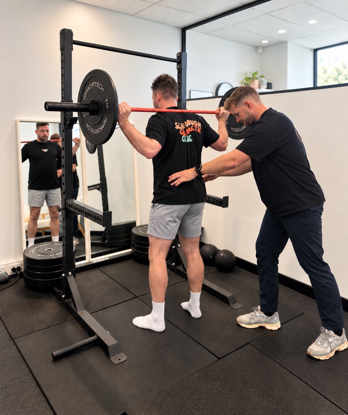 Tim coaching a patient through a squat in the treatment room