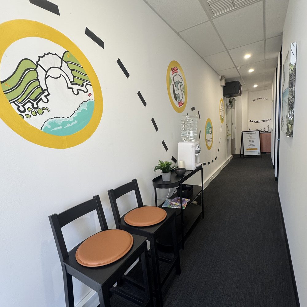 Clinic hallway with hand-painted murals, seating and a water station
