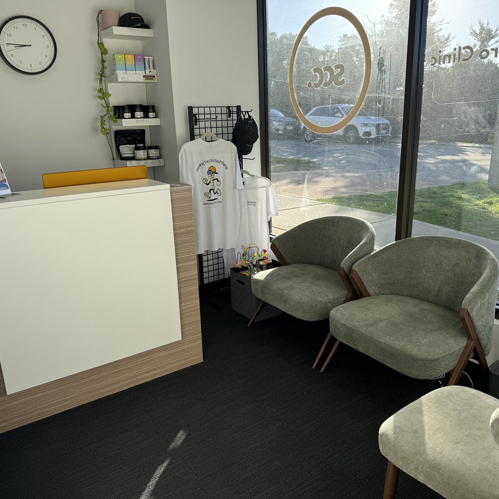 Reception desk and waiting area at Scarborough Chiro Clinic with the gold SCC window decal