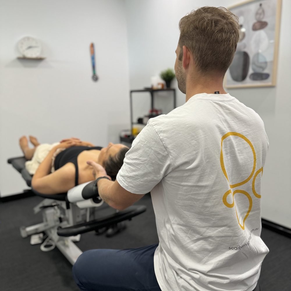 Tim White treating a patient in a treatment room at Scarborough Chiro Clinic