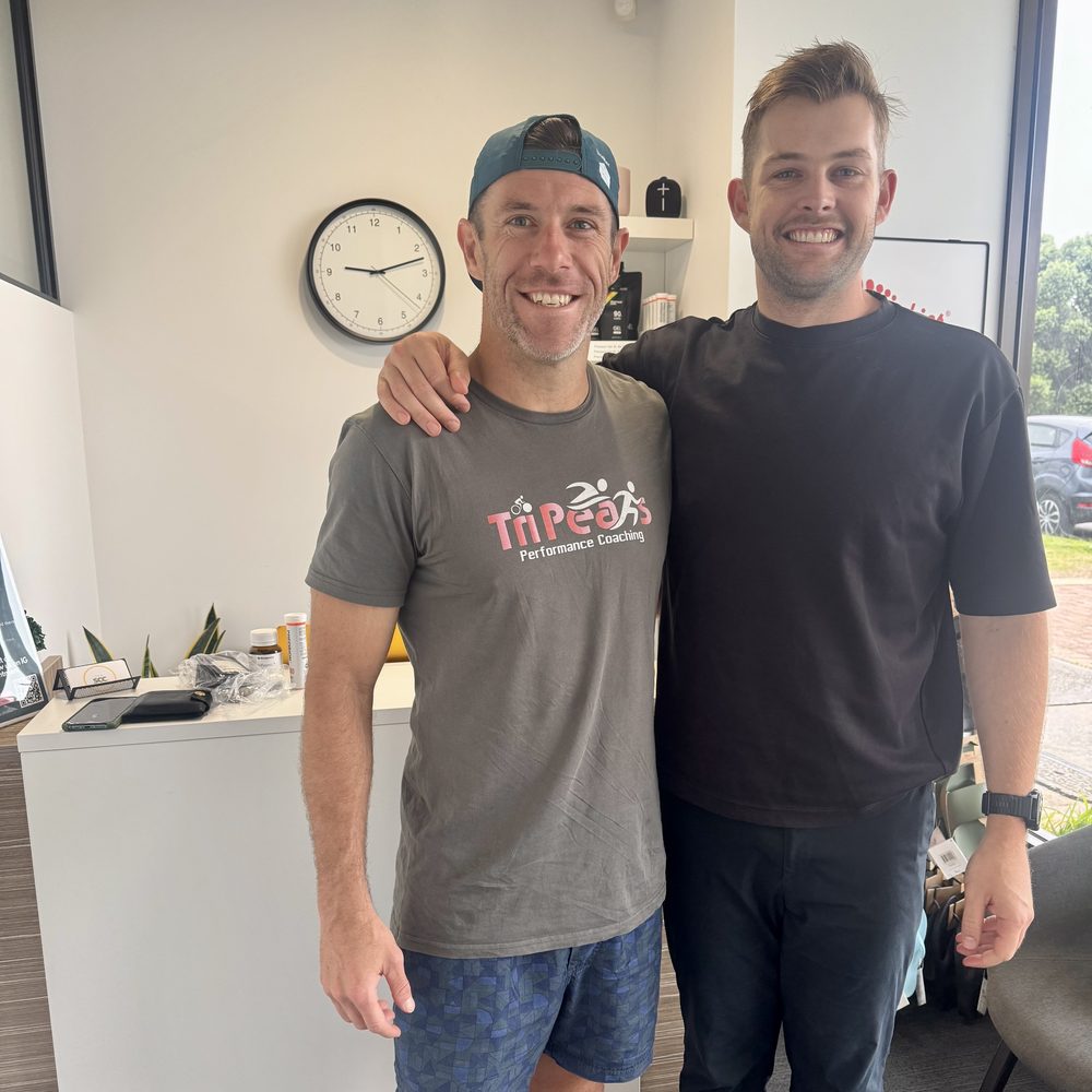 Tim White with a TriPeaks Performance Coaching triathlon coach in the clinic reception